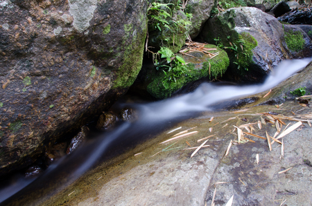 Waterfall with stone of green moss in rain forest , Kiriwong Village, kamloan, Lansaka, Nakhon Si Thammarat, Thailand.の写真素材