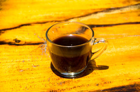 Black coffee on the beachside table with seascape background, nature light. Thailandの写真素材
