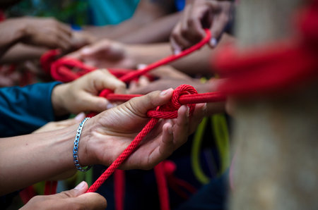 Hands of an adult man knit knots from hemp rope. Selective focus.の写真素材