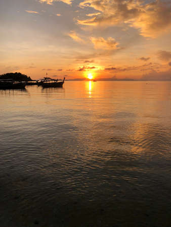 Silhouette beach and Longtail boat on the seaÂ at sunrise time, Satun Thailand.の写真素材