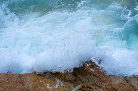 Water splashing. Crystal clear sea water beating against the rocks and cliffs. Waves and sea foam.の写真素材