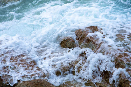 Water splashing. Crystal clear sea water beating against the rocks and cliffs. Waves and sea foam.の写真素材
