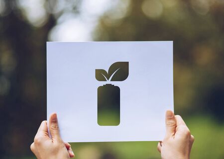 Save world ecology concept environmental conservation with hands holding cut out paper leaves battery saving energy showingの写真素材