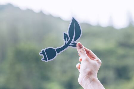 Save world ecology concept environmental conservation with hands holding cut out paper power plug...