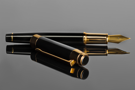 Elegant fountain pen on a black glossy surfaceの写真素材