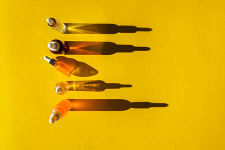 Bottles of nail oil on a bright yellow background. Flatlayの写真素材
