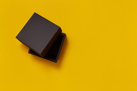 Black paper present box on the yellow background