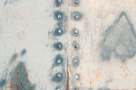 Metal texture with rust and rivets. The background is a fragment of armor plateの写真素材
