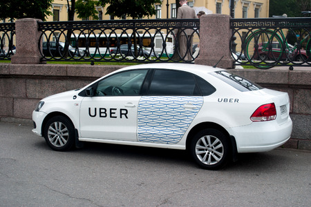 Saint Petersburg, Russia - July 07, 2017: Yellow cab company UBER offers the clients. Residential...