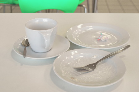 Dirty plates and an empty Cup of coffee after lunch in the cafe.の写真素材