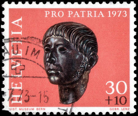 Saint Petersburg, Russia - May 17, 2020: Stamp printed in the Switzerland with the image of the Gallic head from Prilly, Roman Age, circa 1973のeditorial素材