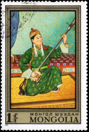 Saint Petersburg, Russia - May 17, 2020: Stamp printed in the Mongolia with the image of The Young musician, circa 1972のeditorial素材