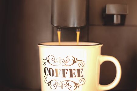 black coffee maker and white Cup of coffee in dark spaceの写真素材