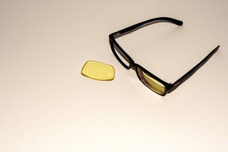 Glasses with a black broken rim lie on a white surfaceの写真素材