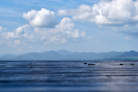 Wood floor with mountain and cloud background in blue toneの写真素材