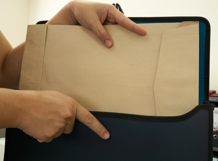 Hand of woman put document in bag