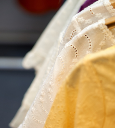 White cloth with thai design with blurry yellow cloth in front and blurry white cloth in backの写真素材