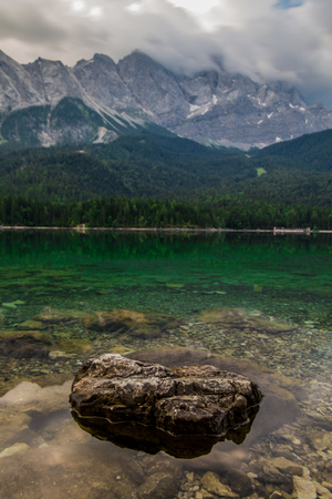 reflections on lake Eibsee with the Zugspitze in the cloudsの写真素材