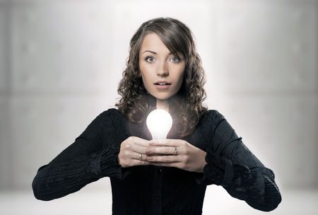 Young girl holding a light bulbの写真素材