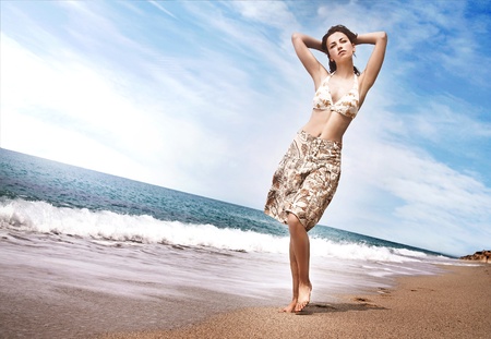 Beautiful young girl walking on the beach の写真素材
