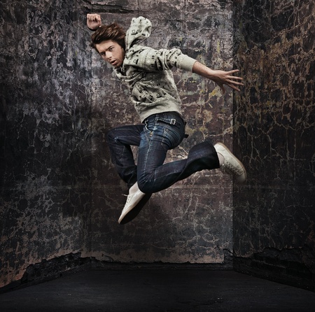 Male dancer posing over grunge wall の写真素材
