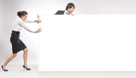 Business people pulling big white board, lots of copyspace の写真素材