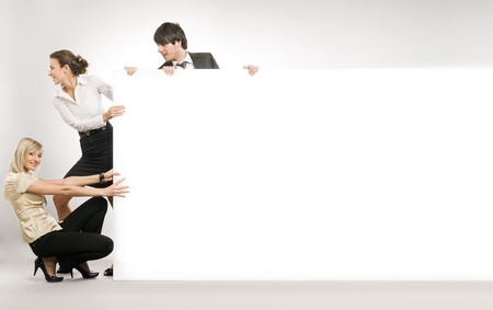 Business people pulling big white board, lots of copyspace の写真素材
