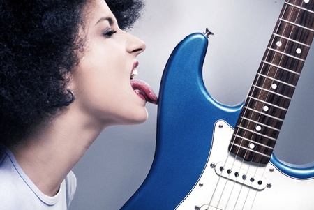 Beautiful rock-n-roll girl licking a guitar の写真素材