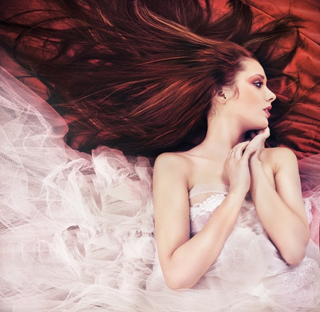 Ginger long haired young woman in sensual poseの写真素材