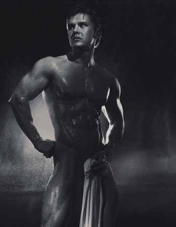 Young handsome athlete standing in the rainの写真素材