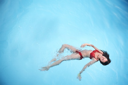 Cute brunette relaxing in a swimming poolの写真素材