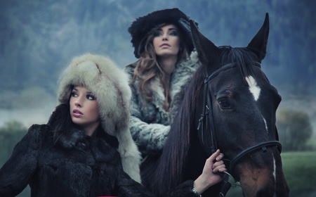 Two romantic female models posing with a horseの写真素材