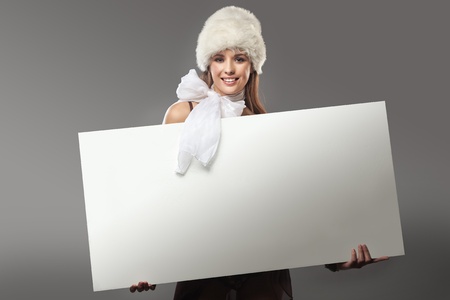 Pretty girl holding a white message boardの写真素材