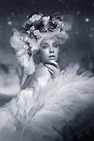 Portrait of a woman in hat made of flowersの写真素材