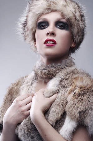 beautiful young blond woman in fur, studio shotの写真素材
