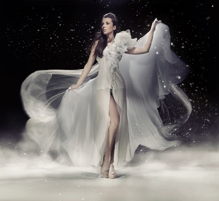 Sensual brunette woman dancing in white dressの写真素材