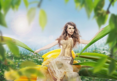 Beautiful young lady sitting on a tulipの写真素材