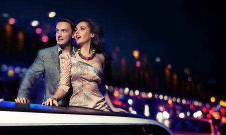 Elegant couple traveling a limousine at nightの写真素材