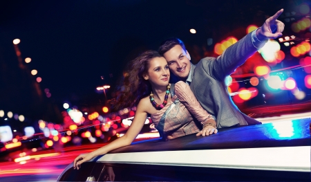 Elegant couple traveling a limousine at nightの写真素材