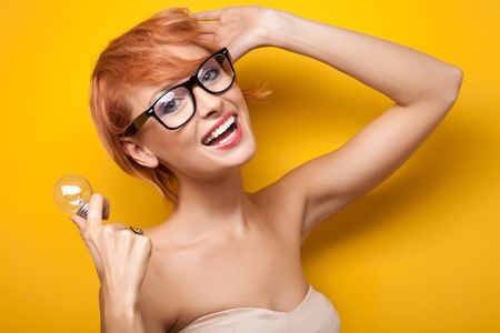 Smiling woman with light bulbの写真素材