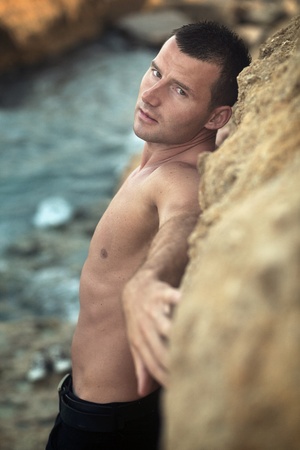 Attractive guy posing on rocksの写真素材