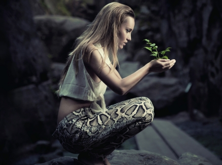 Beautiful young woman holding a plantの写真素材
