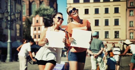Two smiling girls holding empty boardの写真素材