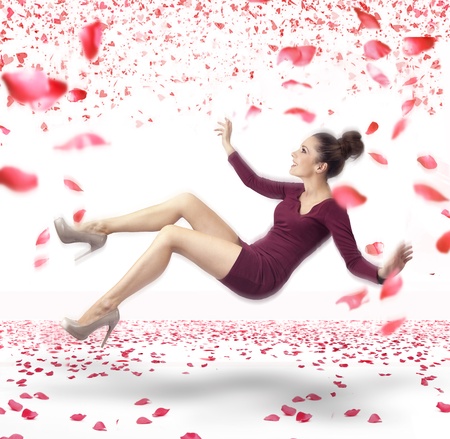 Attractive lady falling down over rose petals in backgroundの写真素材