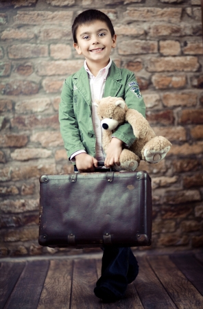 Stylish boy with suitcase and teddybearの写真素材