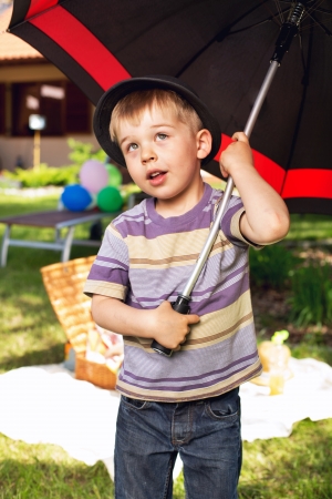 Curious little boy with big umbrellaの写真素材