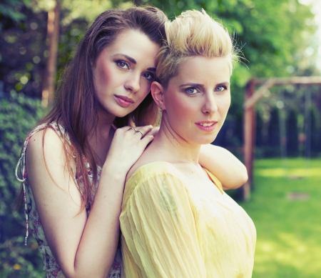 Two attractive ladies posing in the gardenの写真素材