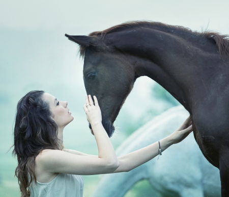 Sensual woman stroking a wild horseの写真素材