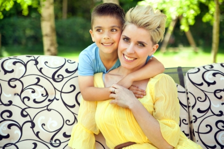 Glad mother hugged by her lovely childの写真素材