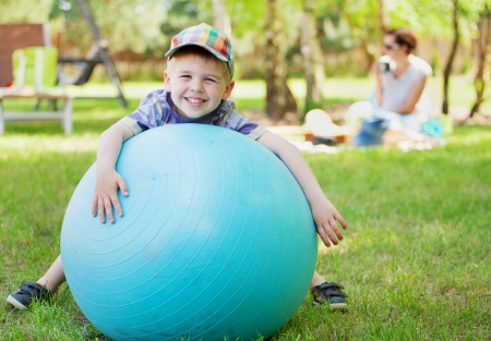 Little gentleman playing a big green ballの写真素材